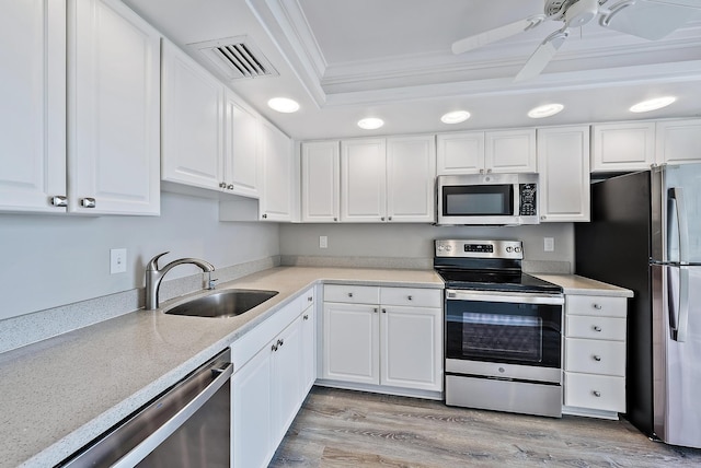 kitchen featuring ornamental molding, white cabinets, stainless steel appliances, and sink