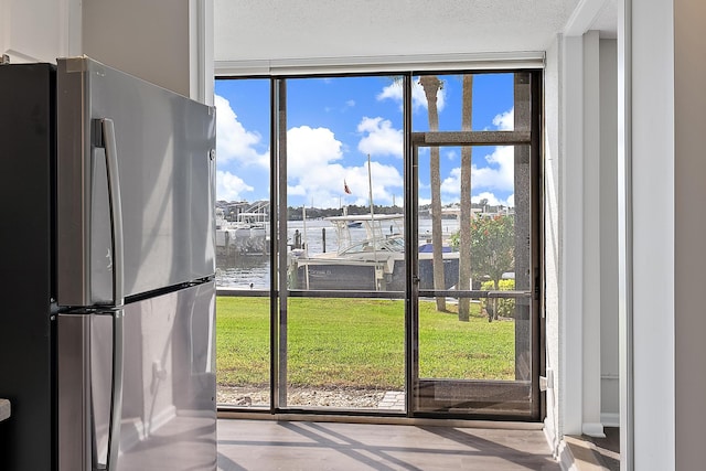 doorway to outside featuring a healthy amount of sunlight and a water view