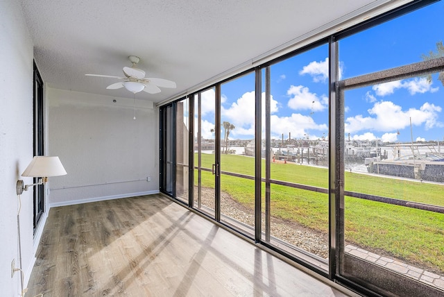 unfurnished sunroom featuring ceiling fan