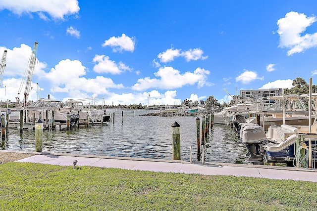 view of dock with a water view and a lawn