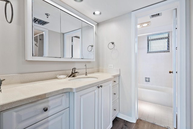 bathroom with vanity, hardwood / wood-style floors, and shower / bathtub combination