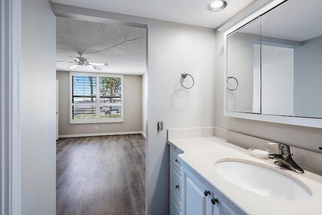 bathroom with vanity, a textured ceiling, hardwood / wood-style flooring, and ceiling fan