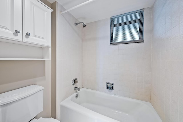 bathroom with toilet and tiled shower / bath combo