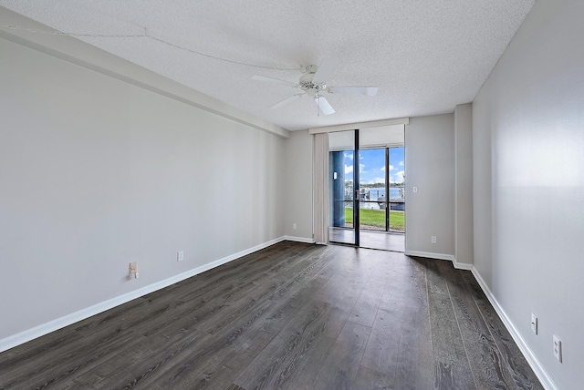 unfurnished room featuring floor to ceiling windows, ceiling fan, a textured ceiling, and dark hardwood / wood-style flooring