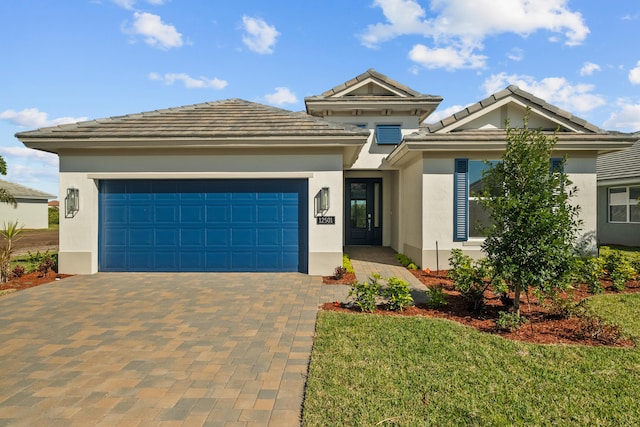 12501 SW Sunrise Lake Ter, Port Saint Lucie, FL 34987 - view of front of home with stucco siding, decorative driveway, an attached garage, a front yard, and a tiled roof