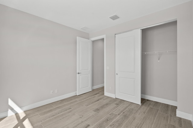 12501 SW Sunrise Lake Ter, Port Saint Lucie, FL 34987 - unfurnished bedroom with light wood finished floors, baseboards, and a closet