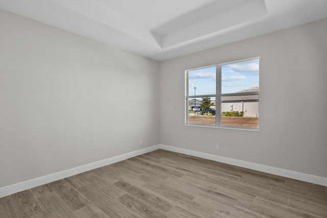 12501 SW Sunrise Lake Ter, Port Saint Lucie, FL 34987 - empty room with wood finished floors, a raised ceiling, and baseboards