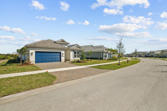 12501 SW Sunrise Lake Ter, Port Saint Lucie, FL 34987 - view of front of house featuring decorative driveway, an attached garage, a front yard, stucco siding, and a residential view