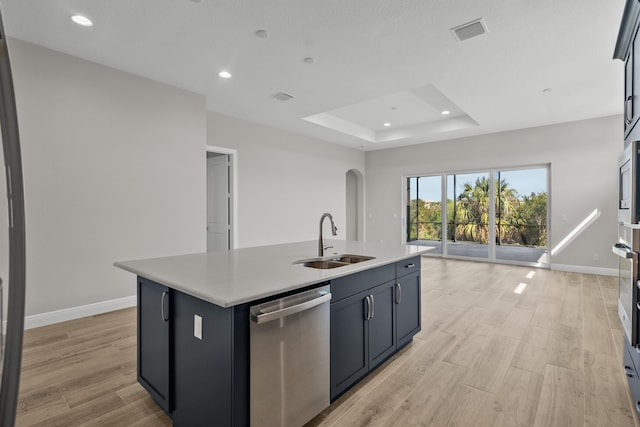 12501 SW Sunrise Lake Ter, Port Saint Lucie, FL 34987 - kitchen with stainless steel appliances, a sink, a center island with sink, a tray ceiling, and light countertops