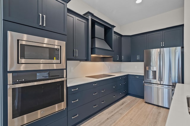 12501 SW Sunrise Lake Ter, Port Saint Lucie, FL 34987 - kitchen with appliances with stainless steel finishes, light wood finished floors, light countertops, and custom range hood
