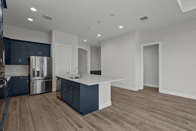 12501 SW Sunrise Lake Ter, Port Saint Lucie, FL 34987 - kitchen with stainless steel appliances, a sink, light wood finished floors, arched walkways, and light countertops