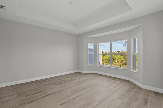 12501 SW Sunrise Lake Ter, Port Saint Lucie, FL 34987 - unfurnished room featuring a raised ceiling, light wood-style floors, and baseboards