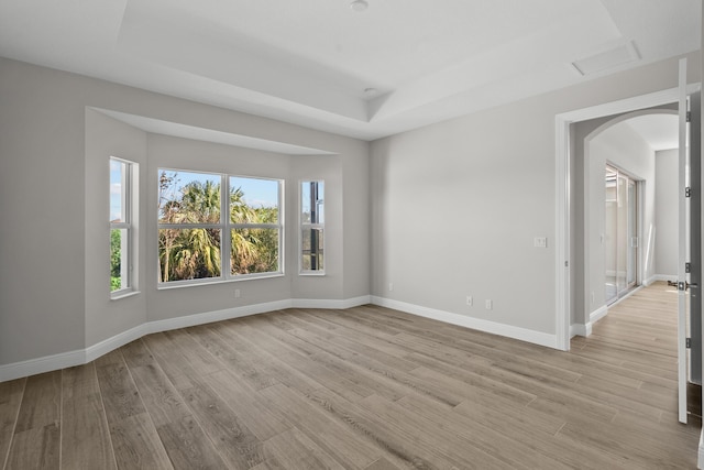 12501 SW Sunrise Lake Ter, Port Saint Lucie, FL 34987 - unfurnished room with arched walkways, light wood-style floors, and baseboards