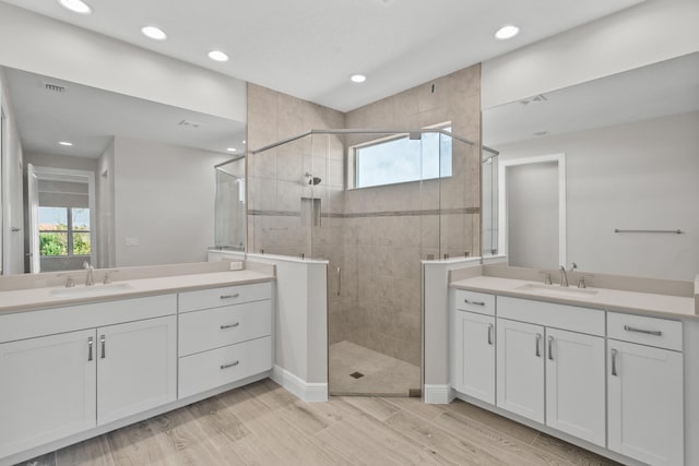 12501 SW Sunrise Lake Ter, Port Saint Lucie, FL 34987 - bathroom featuring a stall shower, two vanities, wood finished floors, recessed lighting, and baseboards