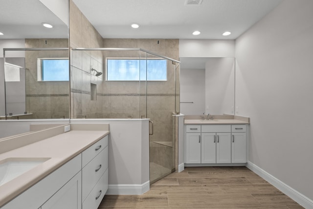 12501 SW Sunrise Lake Ter, Port Saint Lucie, FL 34987 - full bath with two vanities, healthy amount of natural light, a shower stall, wood finished floors, and recessed lighting