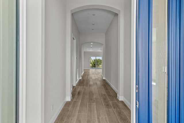 12501 SW Sunrise Lake Ter, Port Saint Lucie, FL 34987 - hallway featuring arched walkways, wood finished floors, and baseboards