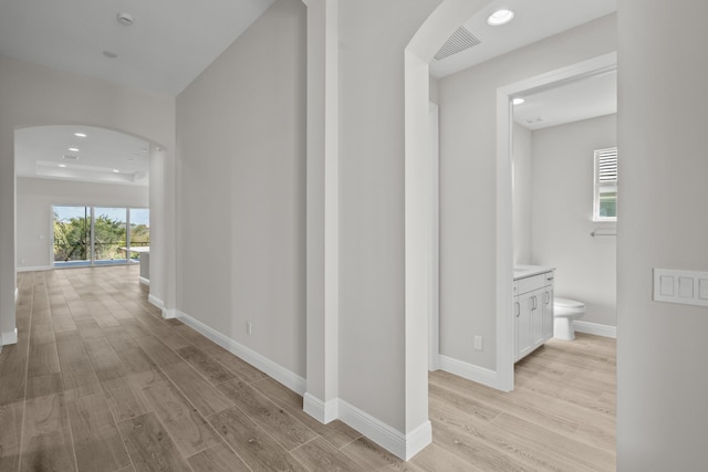 12501 SW Sunrise Lake Ter, Port Saint Lucie, FL 34987 - hallway featuring arched walkways, light wood-type flooring, baseboards, and recessed lighting
