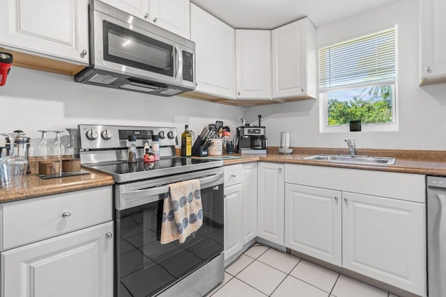 kitchen featuring white cabinetry, light tile patterned floors, appliances with stainless steel finishes, and sink