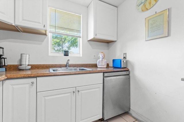 kitchen featuring stainless steel dishwasher, sink, white cabinetry, and light tile patterned floors