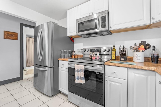 kitchen featuring light tile patterned flooring, white cabinetry, and stainless steel appliances