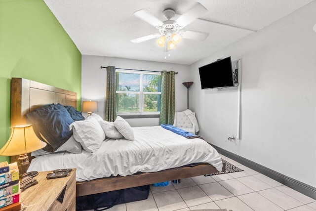 bedroom featuring a textured ceiling, light tile patterned floors, and ceiling fan