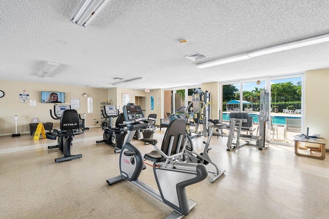 workout area with a textured ceiling and floor to ceiling windows