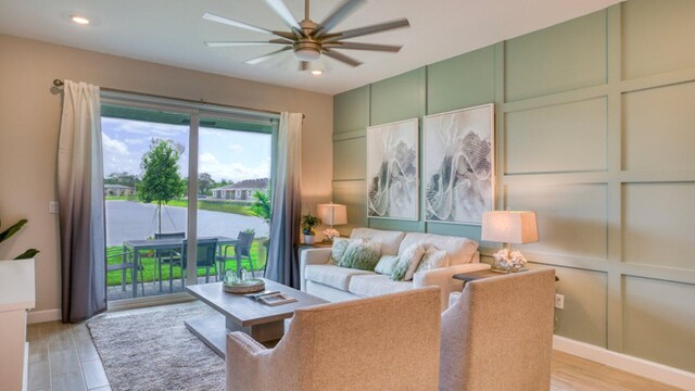 living room featuring a water view, light wood-type flooring, and ceiling fan