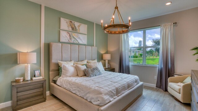 bedroom featuring light hardwood / wood-style flooring and a chandelier