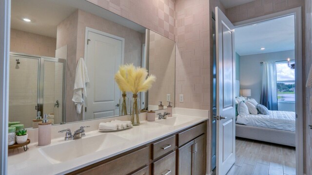 bathroom with a shower with door, vanity, and wood-type flooring