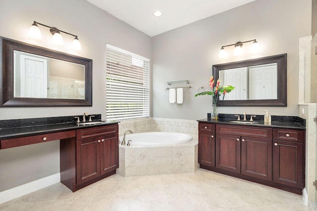 bathroom with vanity, tile patterned flooring, and tiled tub