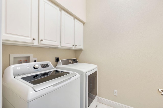 clothes washing area featuring cabinets and independent washer and dryer