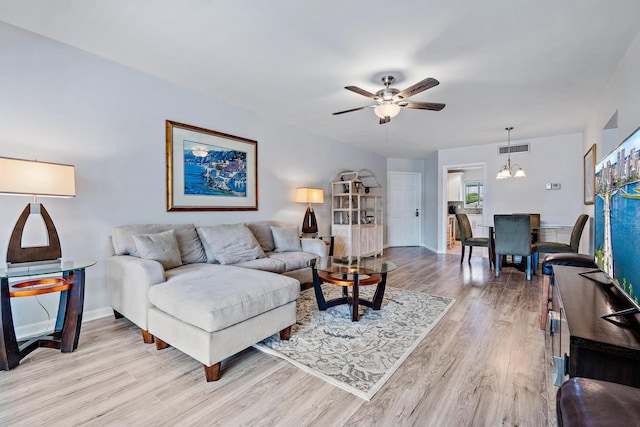 living room featuring light hardwood / wood-style flooring and ceiling fan with notable chandelier