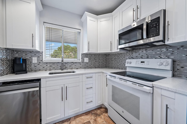 kitchen with white cabinetry, tasteful backsplash, stainless steel appliances, and sink