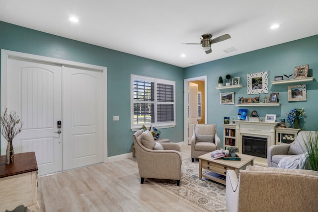 living room featuring ceiling fan and light hardwood / wood-style flooring