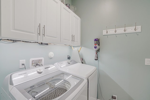 washroom with washer and dryer and cabinets