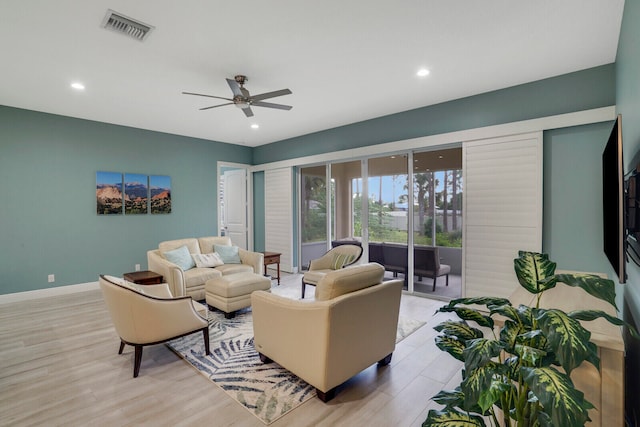 living room with light hardwood / wood-style floors and ceiling fan