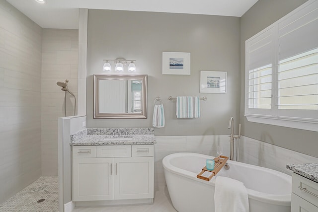 bathroom featuring vanity, tile walls, and plus walk in shower