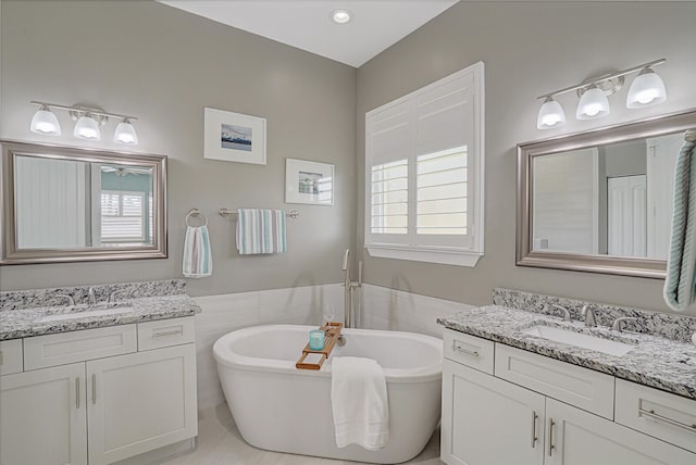 bathroom featuring vanity, tile patterned floors, and a bathtub