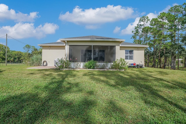 back of house with a yard and a sunroom