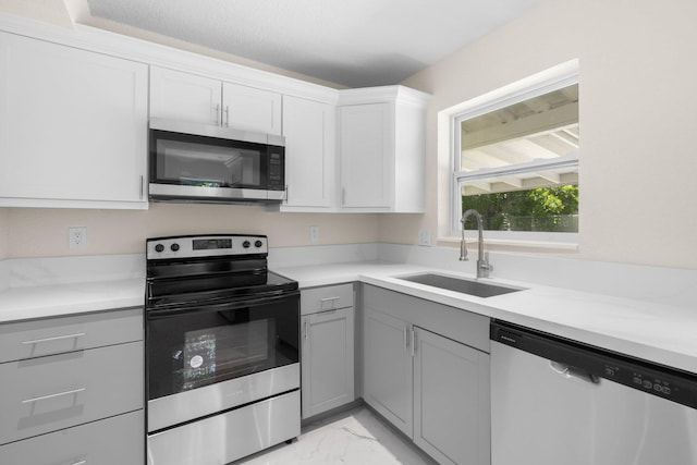 kitchen featuring sink, appliances with stainless steel finishes, gray cabinetry, and white cabinets