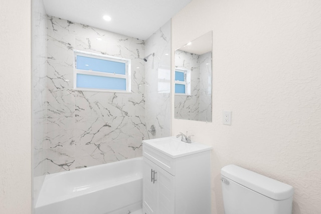 full bathroom with vanity, tiled shower / bath combo, and toilet