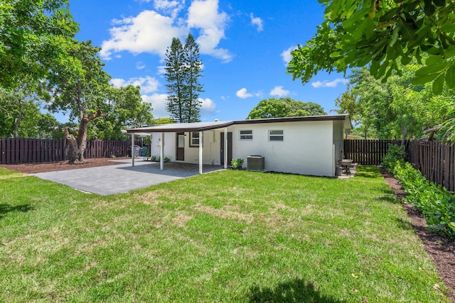 rear view of house with central AC, a yard, and a patio area