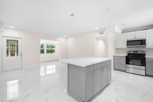 kitchen with appliances with stainless steel finishes, a center island, and gray cabinets