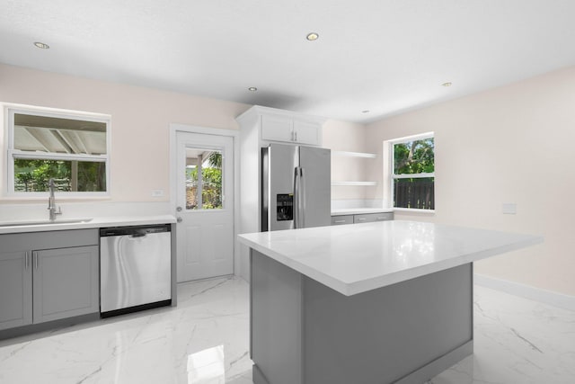 kitchen with a wealth of natural light, a center island, gray cabinetry, and stainless steel appliances