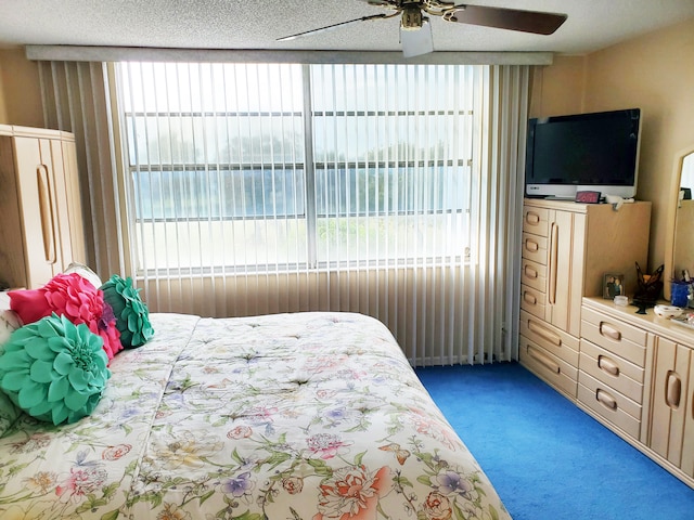 carpeted bedroom with ceiling fan and a textured ceiling