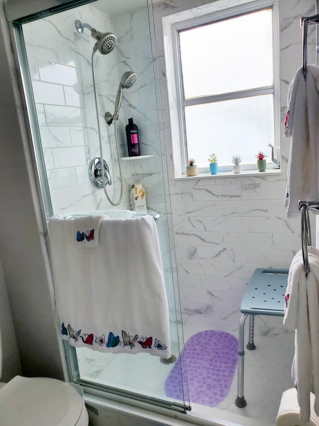 bathroom with toilet and a shower with shower door