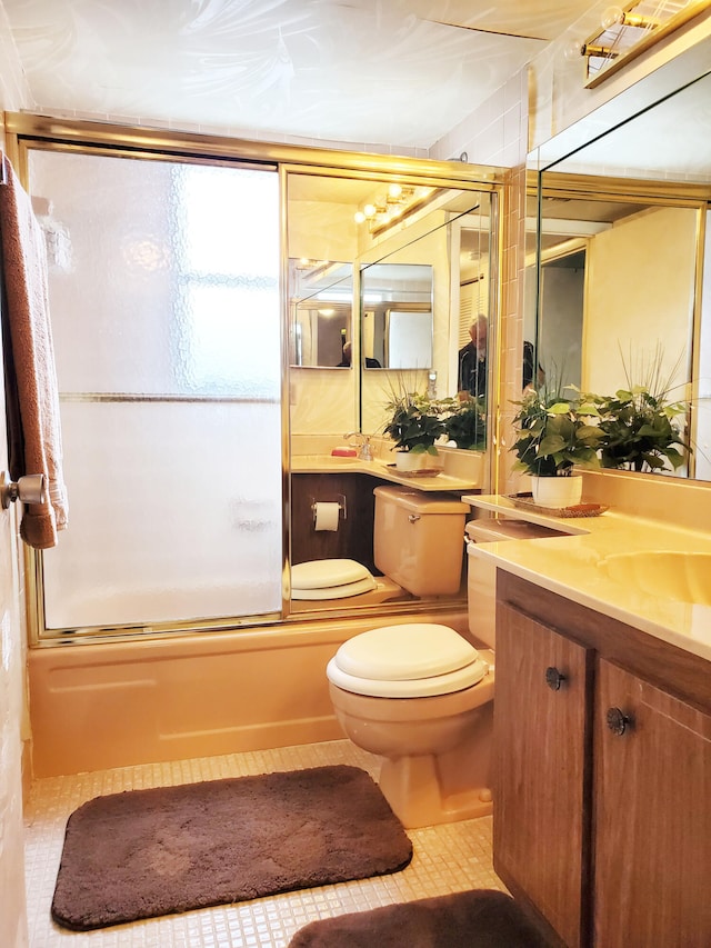 full bathroom featuring vanity, bath / shower combo with glass door, toilet, and tile patterned floors