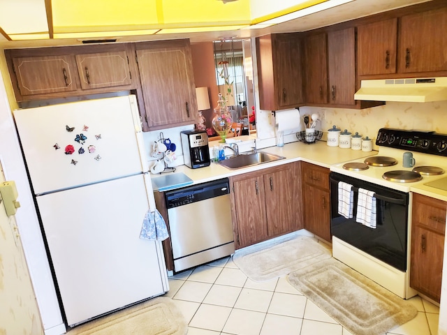 kitchen featuring white appliances, light tile patterned floors, and sink