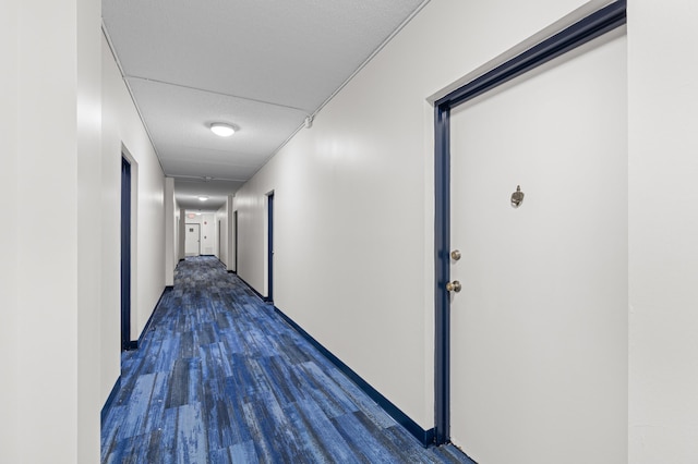 corridor featuring a textured ceiling and dark hardwood / wood-style floors