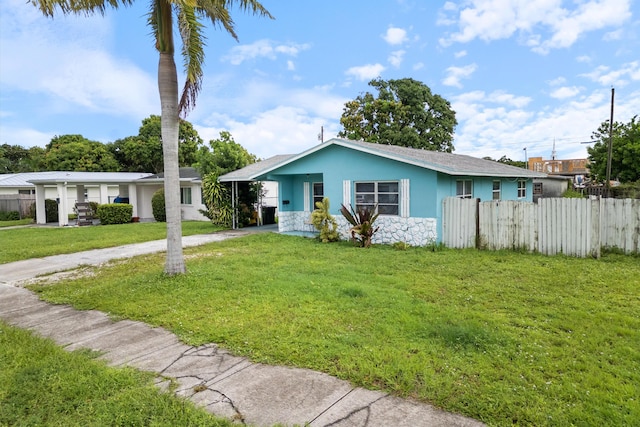 ranch-style house featuring a front lawn and a carport